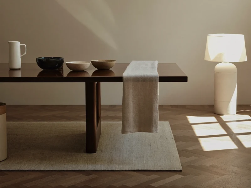 Colț luminos de living și zonă de masă, cu ceramică, in și o lampă